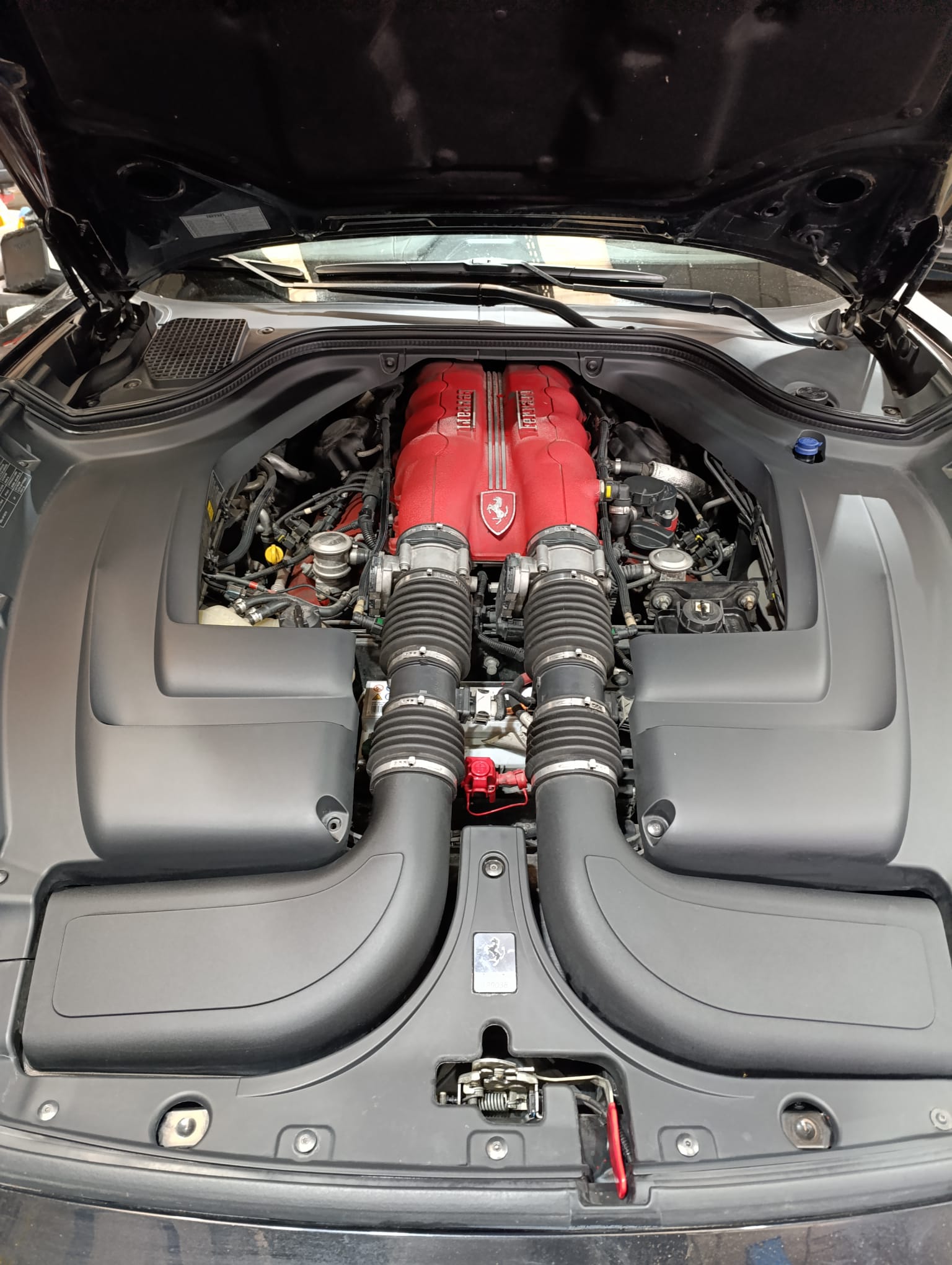 Vano motor Ferrari con polvo y suciedad antes del detailing